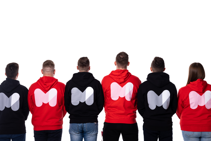 People standing backwards on a white background in a Mobile Reality hoodie