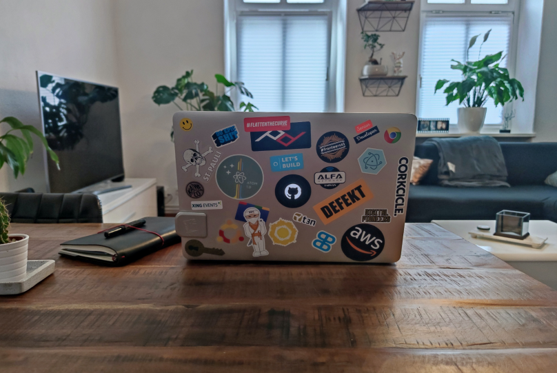  a laptop with AWS stickers on a brown table
